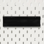 Schwarze Pegboard Schiene montiert an weißer Lochwand
